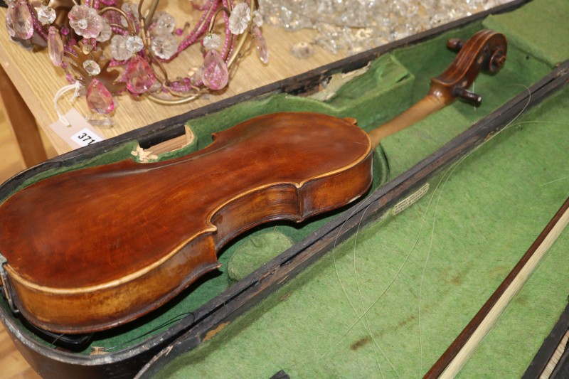 An early 20th century Saxon violin cased with bow and a cased banjo